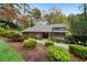 Exterior view of the house surrounded by lush landscaping and mature trees at 5525 Whitner Dr, Sandy Springs, GA 30327