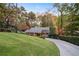 Charming single-Gathering home with a well-manicured lawn and a paved driveway nestled among trees at 5525 Whitner Dr, Sandy Springs, GA 30327