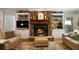 Cozy living room featuring a stone fireplace, built-in shelving, hardwood floors and comfortable seating at 5525 Whitner Dr, Sandy Springs, GA 30327