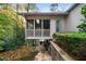 Exterior view of a screened porch with stairs leading down to a stone patio and landscaped area at 5525 Whitner Dr, Sandy Springs, GA 30327