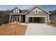New construction home featuring a covered porch with brick accents and an attached two-car garage at 2017 Ripple Park Bnd, Canton, GA 30114