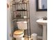 Cozy bathroom with a toilet, sink, and a storage shelf with decorative items at 2403 Brianna Dr, Hampton, GA 30228