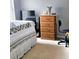 A bedroom with a white comforter with a floral pattern on the bed and a wooden dresser in the corner at 2403 Brianna Dr, Hampton, GA 30228
