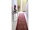 Inviting entryway featuring a stylish console table, red oriental rug, and a decorative vase with flowers at 2403 Brianna Dr, Hampton, GA 30228