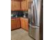 Modern kitchen with wooden cabinets, stainless steel refrigerator, and tile flooring at 2403 Brianna Dr, Hampton, GA 30228