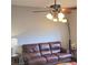 Inviting living room featuring a leather sofa, ceiling fan with lights, and a floor lamp at 2403 Brianna Dr, Hampton, GA 30228
