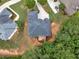 Luxury home with a deck, lawn, and mature trees in a wooded neighborhood, as seen from above at 1258 Mcallistar Dr, Locust Grove, GA 30248