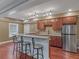 Kitchen wet bar with granite countertops, wooden cabinets, stainless steel fridge, and three chairs at 1258 Mcallistar Dr, Locust Grove, GA 30248