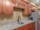 Kitchen wet bar featuring granite countertops, wooden cabinets, a stainless steel sink and a stainless steel fridge at 1258 Mcallistar Dr, Locust Grove, GA 30248