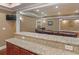 Kitchen wet bar featuring granite countertops and wooden cabinets with a view of the adjacent living room at 1258 Mcallistar Dr, Locust Grove, GA 30248