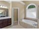Bright bathroom with a jetted tub, large window, and vanity with ample counter space at 1258 Mcallistar Dr, Locust Grove, GA 30248