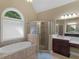 Relaxing bathroom featuring a jetted tub, glass-enclosed shower, and a large vanity area at 1258 Mcallistar Dr, Locust Grove, GA 30248