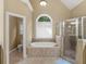 Elegant bathroom featuring a jetted tub, separate shower, and neutral tile at 1258 Mcallistar Dr, Locust Grove, GA 30248