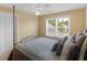 Bright bedroom featuring a four-poster bed with a ceiling fan and a view of trees through the window at 1258 Mcallistar Dr, Locust Grove, GA 30248