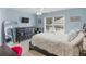 Light blue bedroom with large window, ceiling fan, and a dark wood dresser with tv on top at 1258 Mcallistar Dr, Locust Grove, GA 30248