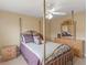 Bedroom with a gold metal canopy bed, a ceiling fan, and a wooden dresser with mirror on top at 1258 Mcallistar Dr, Locust Grove, GA 30248