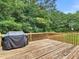 Spacious wooden deck features a grill and overlooks a lush green backyard with mature trees at 1258 Mcallistar Dr, Locust Grove, GA 30248