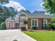 Stunning two-story brick home featuring manicured lawn, driveway, and mature landscaping at 1258 Mcallistar Dr, Locust Grove, GA 30248