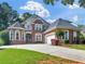 Stately two-story brick home with a manicured lawn, a circular driveway and an attached two car garage at 1258 Mcallistar Dr, Locust Grove, GA 30248