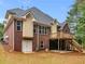 View of the home's brick exterior, upper deck, and covered back patio at 1258 Mcallistar Dr, Locust Grove, GA 30248