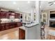 An open-concept kitchen features granite counters, cherry cabinets, a stainless dishwasher, and hardwood floors at 1258 Mcallistar Dr, Locust Grove, GA 30248