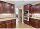 Stylish kitchen features granite countertops, stainless steel appliances, and dark wood cabinets at 1258 Mcallistar Dr, Locust Grove, GA 30248