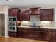 A kitchen showcases stainless steel appliances and dark wood cabinetry with granite countertops at 1258 Mcallistar Dr, Locust Grove, GA 30248