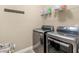 Modern laundry room featuring front-load washer and dryer with a convenient wall-mounted rack at 1258 Mcallistar Dr, Locust Grove, GA 30248