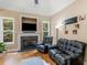 Cozy living room showcasing a fireplace, large windows offering natural light, and comfortable dark seating at 1258 Mcallistar Dr, Locust Grove, GA 30248