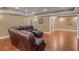 Open-concept living room boasts hardwood floors and a comfortable brown leather sofa with recliners at 1258 Mcallistar Dr, Locust Grove, GA 30248