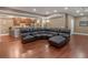 Spacious living room with a dark brown leather sectional sofa and hardwood flooring at 1258 Mcallistar Dr, Locust Grove, GA 30248
