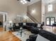 Spacious living room featuring hardwood floors, large leather sectional, and a staircase leading to the second floor at 1258 Mcallistar Dr, Locust Grove, GA 30248