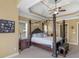 The main bedroom boasts a trey ceiling, four-poster bed, and natural light from two windows at 1258 Mcallistar Dr, Locust Grove, GA 30248