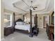 Large main bedroom suite with four poster bed, tray ceiling, large windows, and stylish decor at 1258 Mcallistar Dr, Locust Grove, GA 30248
