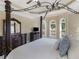 Expansive main bedroom with a four-poster bed, sitting area, and views of the landscaped yard at 1258 Mcallistar Dr, Locust Grove, GA 30248