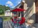 Outdoor patio area featuring a table, chairs, and a red umbrella on the patio at 1258 Mcallistar Dr, Locust Grove, GA 30248