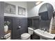 Stylish powder room featuring modern fixtures, gray wainscoting, decorative wall art, and a pedestal sink at 364 Concord St, Alpharetta, GA 30009