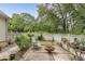 Relaxing backyard features a small patio, lounge chair, privacy fence, and mature trees at 3157 Oakdale Rd, Hapeville, GA 30354