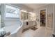 Bright bathroom featuring a soaking tub, double sink vanity, and walk-in closet at 3157 Oakdale Rd, Hapeville, GA 30354