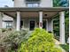 Inviting covered front porch with square columns and lush landscaping creates curb appeal at 3157 Oakdale Rd, Hapeville, GA 30354