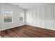 Empty dining room with wainscotting, dark laminate flooring and two sunlit windows at 4102 Dinmont Chase, Atlanta, GA 30349