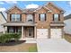 Charming two-story brick home featuring a well-manicured lawn and attached two-car garage at 4102 Dinmont Chase, Atlanta, GA 30349