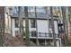 View of the back exterior of the home with a deck overlooking lush greenery at 4830 Rebel Nw Trl, Sandy Springs, GA 30327