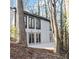 Exterior of home showcasing a back patio, large windows, and mature trees at 4830 Rebel Nw Trl, Sandy Springs, GA 30327
