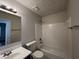 Bathroom with tub-shower combo, and white tiled walls at 3713 Cameron Hills Pl, Ellenwood, GA 30294