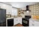 Modern kitchen features stainless appliances, white cabinets, and decorative backsplash at 2003 Cogar Dr, Decatur, GA 30032