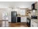 Modern kitchen features a black fridge, stainless steel appliances, and sleek white cabinets at 2003 Cogar Dr, Decatur, GA 30032