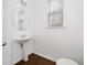 Simple half bath with pedestal sink, wooden floors and a round mirror at 96 Trailview Lane Ln, Hiram, GA 30141