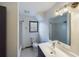 Bright bathroom featuring a white vanity, tiled floor, and a shower with a glass-block window at 1017 Martin Luther King Jr Dr, Atlanta, GA 30314