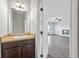 A clean powder room with granite counter and cabinet, leading to a living room with fireplace at 2098 Bridgewater Pass, Hampton, GA 30228